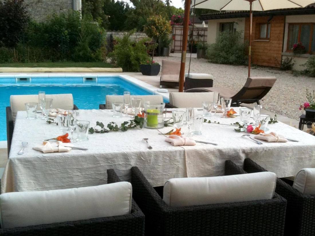 Table dressée en plein air au bord de la piscine